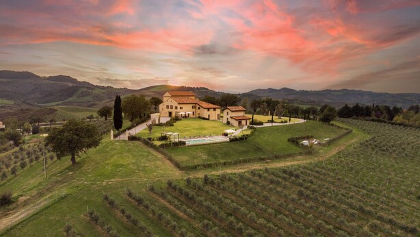 Une vaste villa de style traditionnel, dotée d’une cour spacieuse et entourée de vignobles et de collines verdoyantes.