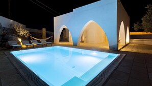 A swimming pool with a lighted edge, surrounded by lounge chairs and a hammock. - Villa Floria 4, Emma Villas (Gagliano del Capo)