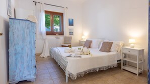 A bedroom with a bed, two bedside tables, a nightstand, a wardrobe, a window with curtains, and a chair. - Villa Floria 4, Emma Villas (Gagliano del Capo)