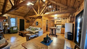 A cozy cabin interior with a dining area, kitchen, and living room.