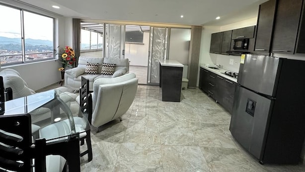 Una cocina moderna con comedor, ventanas amplias y vistas a la ciudad.