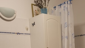 A bathroom with a white sink, a mirror, a cabinet, and a shower curtain.