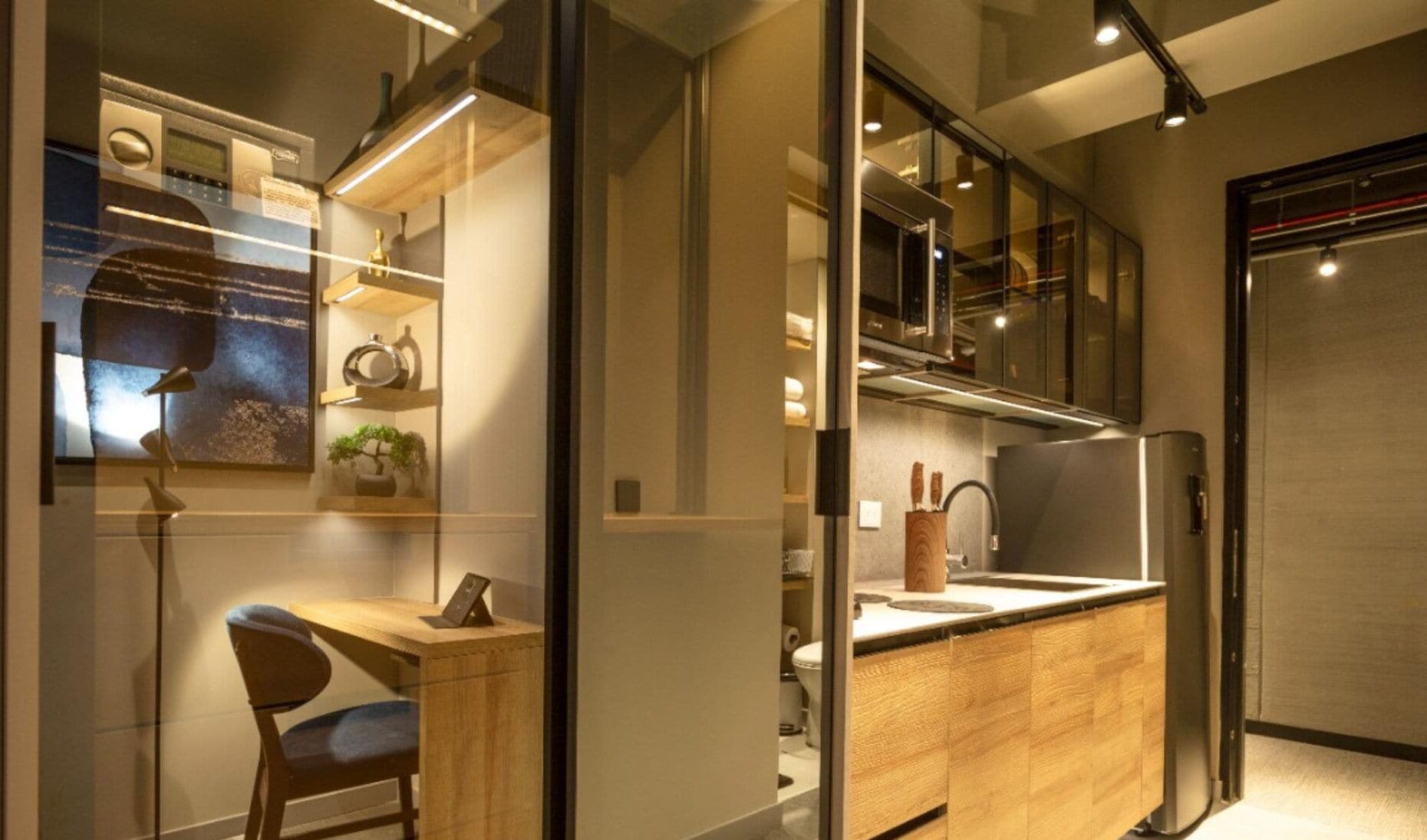 A modern kitchen with a wooden countertop, a built-in oven, and a refrigerator.