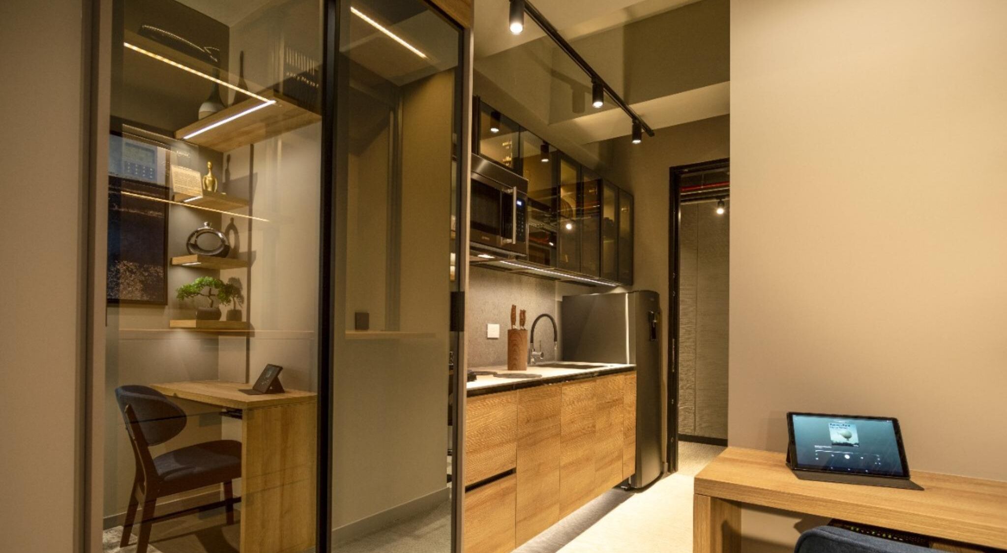 A modern kitchen with a wooden countertop, a refrigerator, and a laptop on a table.