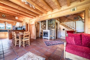 Un intérieur en bois comprenant un coin repas, une cheminée et un escalier.