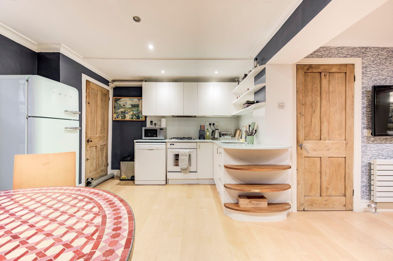 A compact kitchen with white cabinets, a microwave, a stove, and a sink.