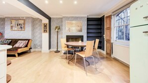 Una cucina moderna con zona pranzo, caratterizzata da un camino, un frigorifero e una finestra con vista.