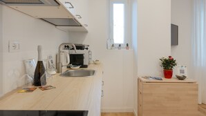 A compact kitchen with a sink, a microwave, and a small window. - Alexander's Nest (Trieste)