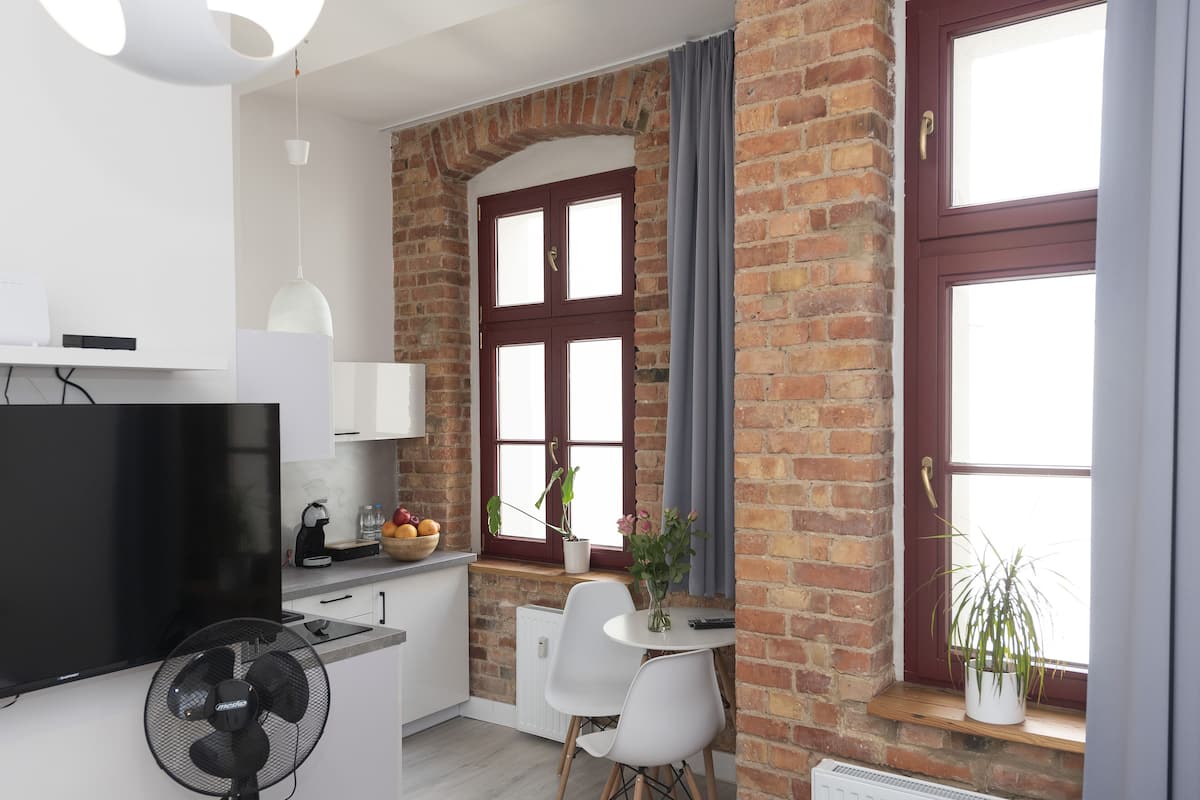 Une cuisine moderne équipée d’un téléviseur à écran plat, d’un ventilateur et d’un coin repas avec une table et des chaises.