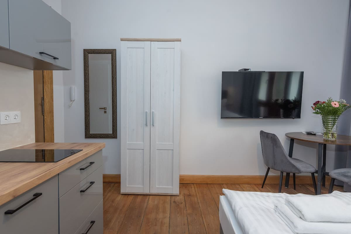 Une chambre moderne comprenant un lit, un bureau, une chaise, une armoire et un téléviseur.