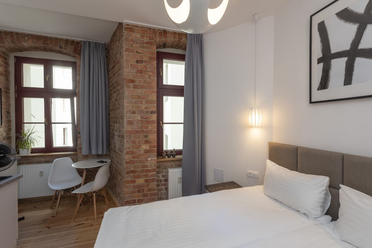 Une chambre d’hôtel avec un lit, un bureau et deux chaises.