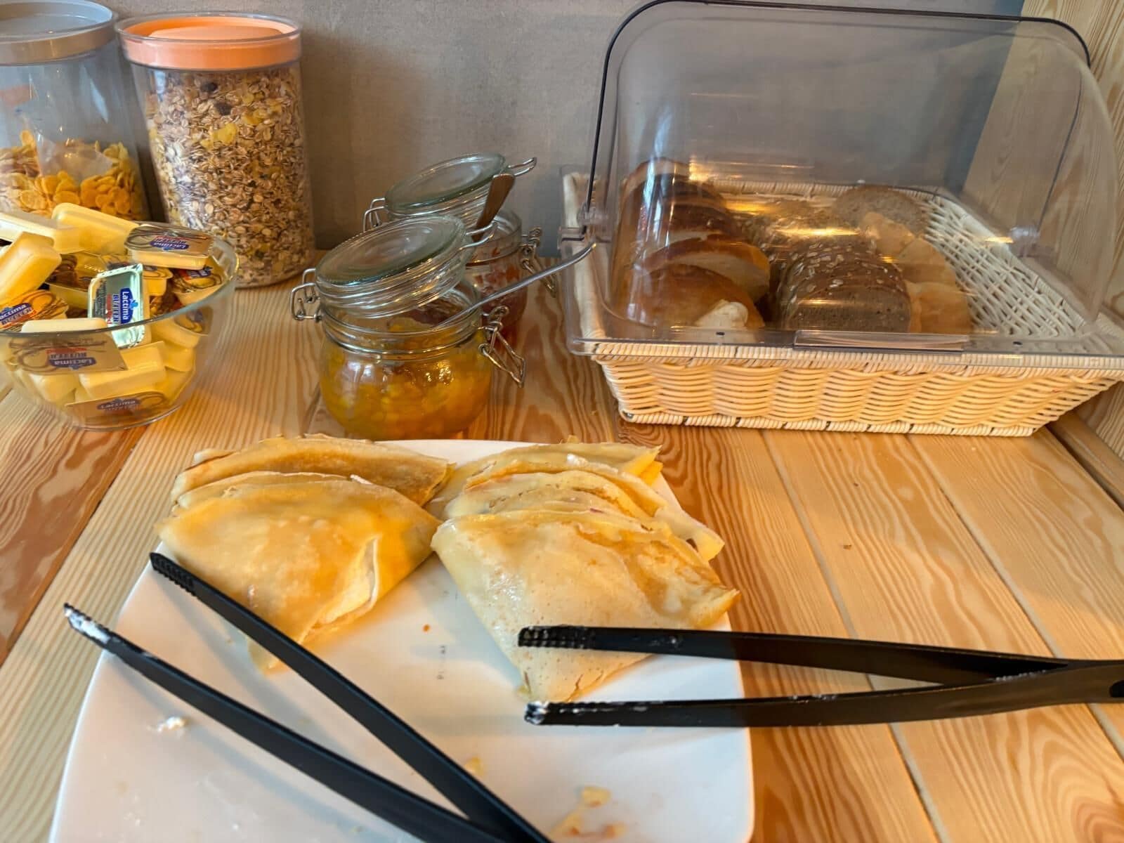 Un buffet de petit-déjeuner proposant une variété d’aliments, notamment des viennoiseries, des céréales et des condiments.