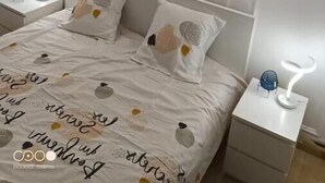A neatly arranged bedroom with a large bed, two bedside tables, and wall-mounted lamps. - Aramis Colibri 72m2, lit King-size, Baignoire duo (Paris)