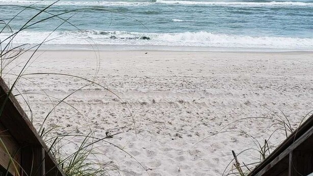 Una spiaggia con sabbia e onde.