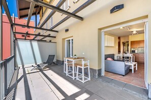 Un appartement moderne doté d’un balcon, d’un coin repas et d’un salon.