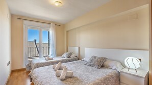 A hotel room with two beds, a nightstand, a lamp, and a window with a view. - Superior Apartment 31 C with Mountain Views, Private Terrace, and Wi-Fi (Sierra Nevada)