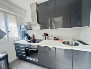 Una cocina moderna con microondas, tostadora y pileta de acero inoxidable.