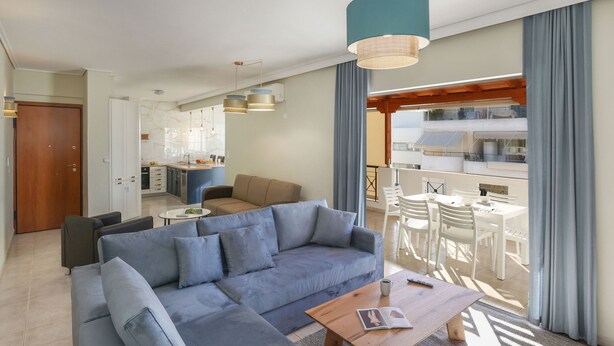 Ein modernes Wohnzimmer mit einem grauen Sofa, einem Holztisch und einem Balkon mit weißer Möbel.