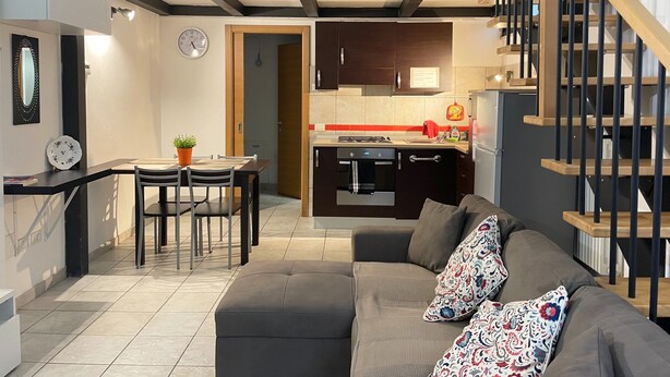 A modern apartment with a dining area, kitchen, and living room.