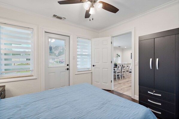 A bedroom with a bed, a ceiling fan, and a wardrobe.