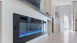 Eine moderne Küche mit integriertem Aquarium, einer weißen Arbeitsplatte und einer Treppe, die zu einer anderen Ebene führt.
