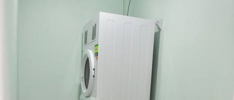 A laundry room with a washing machine, a dryer, and a sink.
