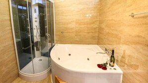 A modern bathroom with a glass-enclosed shower, a freestanding bathtub, and a wooden bench. - Suites Machupicchu (Machu Picchu)