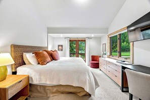 Une chambre à coucher comprenant un lit, une table de chevet, une commode et un bureau avec une chaise.