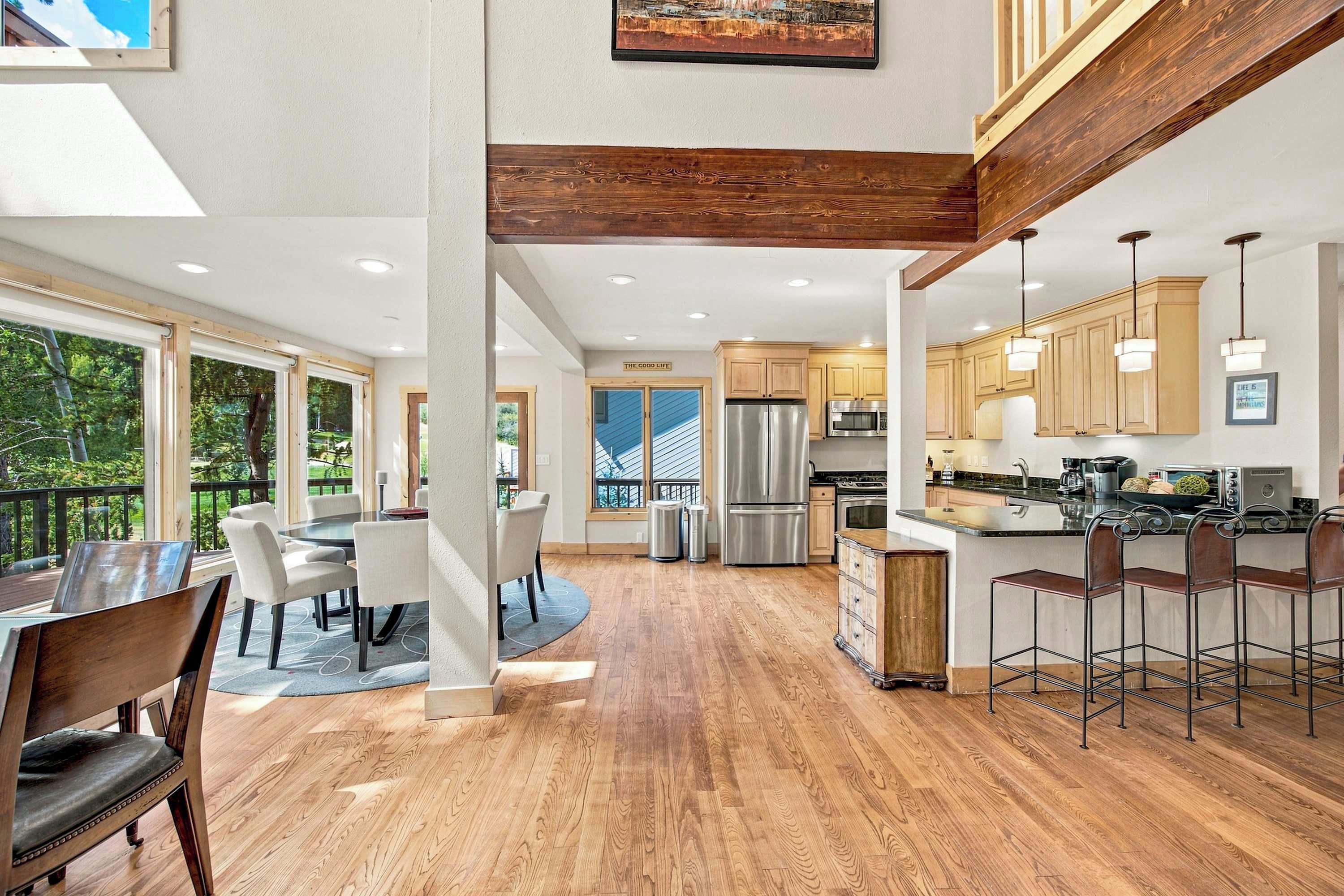 A modern kitchen with wooden cabinets, stainless steel appliances, and a bar area.