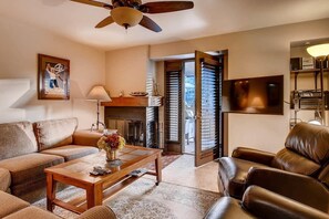 Relax in this inviting living room with a comfortable sofa, fireplace, and balcony access.