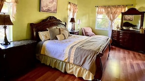 A bedroom with a wooden bed, a ceiling fan, and a window with curtains. - Spacious 4BD/4BA Dream Villa w/LRG Backyard in PSL (Port St. Lucie)
