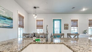A kitchen with granite countertops, a white sink, and a blue door. - Blue Fish on Firefly Park (Carlton Landing)
