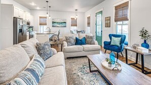 A spacious living area with a sofa set, a coffee table, and a blue armchair. - Blue Fish on Firefly Park (Carlton Landing)