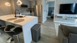 Una cucina moderna con isola centrale, elettrodomestici in acciaio inossidabile e zona pranzo con sgabelli da bar.