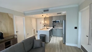 Un appartamento moderno con zona living, angolo cottura e sala da pranzo.