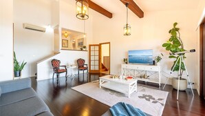 A spacious living room with a staircase, a dining area, and a large window with a view. - Casa Carinho, 24 Wallawa Rd - spectacular water views, pet friendly, air con and Wi-Fi (Nelson Bay)