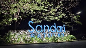A sign with the name "Sandari" and "BATHING" in large blue letters, set against a backdrop of trees and a rocky wall. - Staycation at Sandari Batulao
Mountain side Living (Tagaytay)