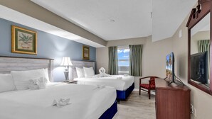 A hotel room with two beds, a desk, a chair, a television, and a window with curtains. - Atlantica Resort Condo🍹Oceanfront (Myrtle Beach)