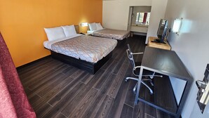 Una habitación de hotel con dos camas, un escritorio, una silla y un televisor.