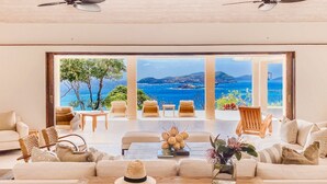 Un salon spacieux doté d’une grande fenêtre offrant une vue imprenable sur l’océan.