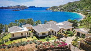 Une propriété située sur la côte, comprenant plusieurs maisons, offrant une vue dégagée sur l’océan et entourée d’une végétation luxuriante.