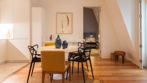 Un coin repas avec une table ronde, des chaises et un vase posé sur la table.
