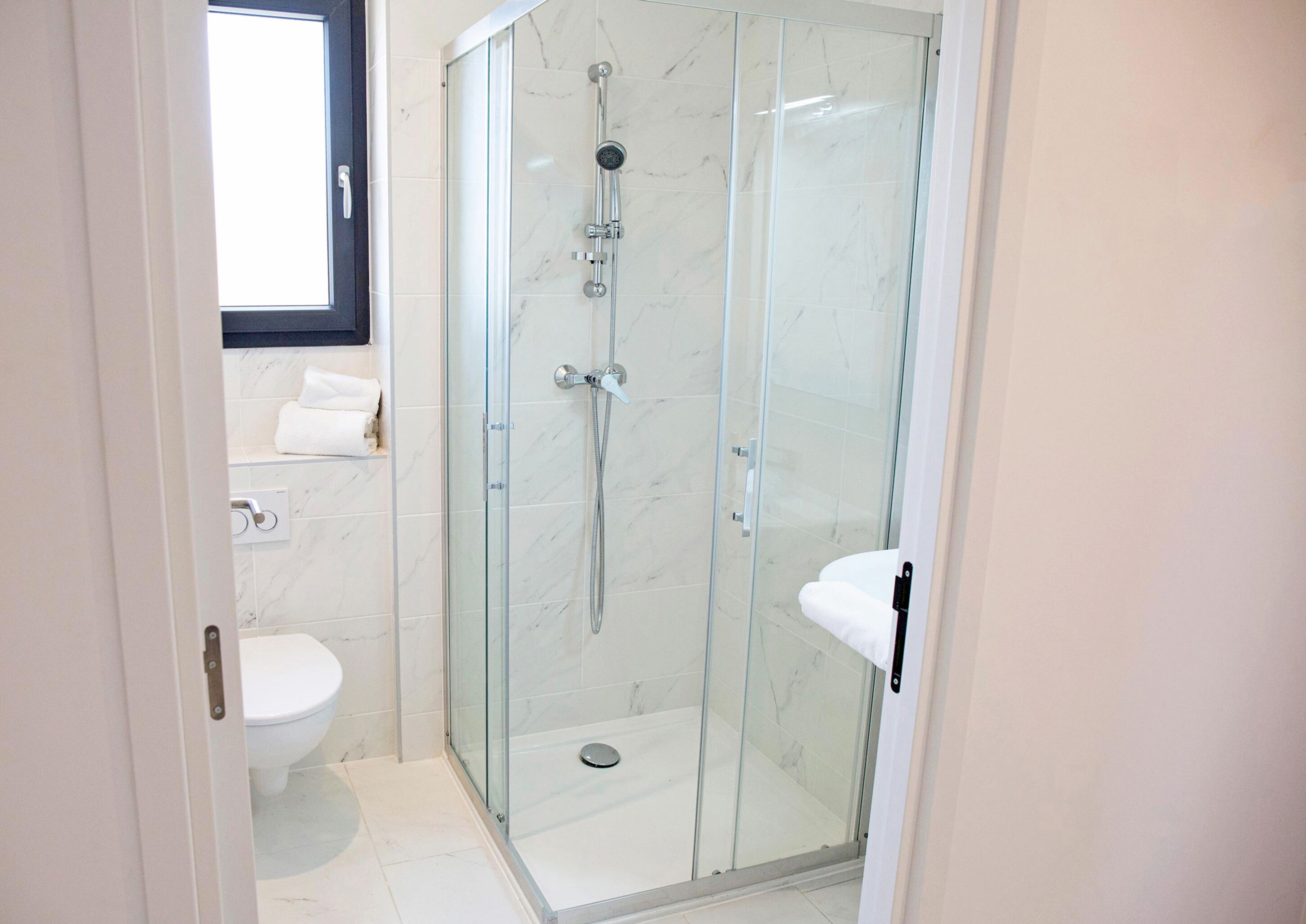 Une salle de bain moderne avec une douche à parois de verre, des toilettes et un lavabo.