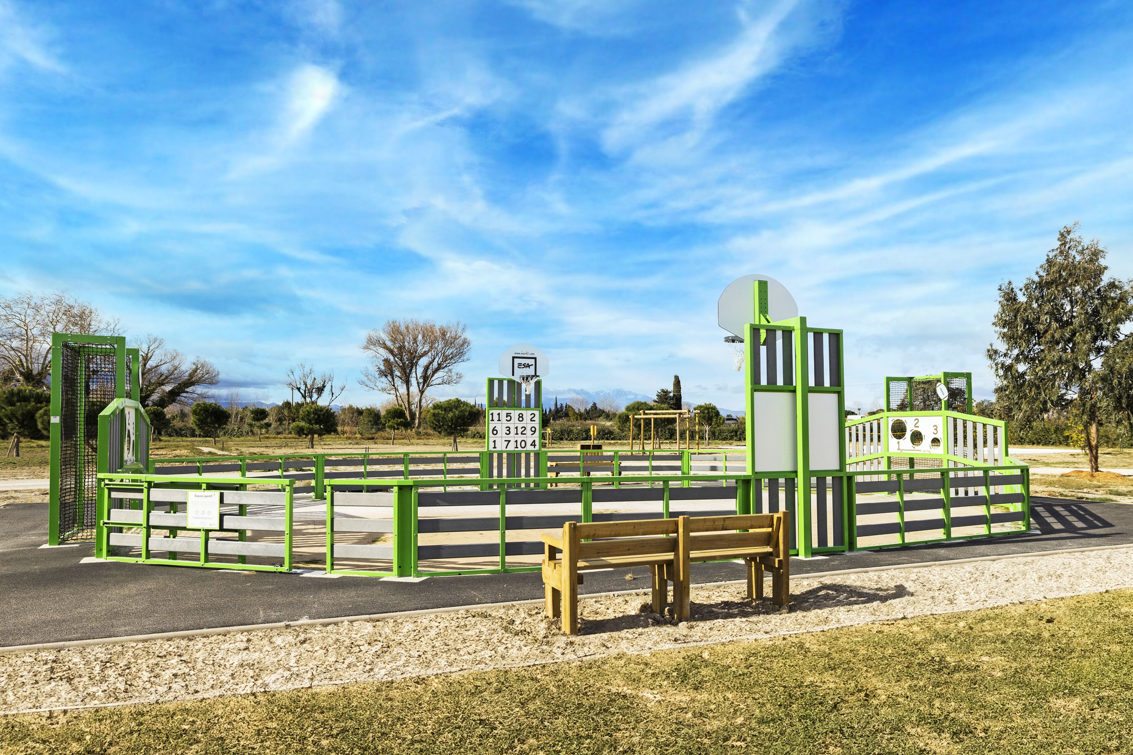 A playground with green structures and a wooden bench.