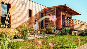 Un bâtiment moderne en bois, doté d’un toit en pente et d’un espace extérieur abrité.