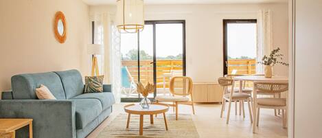 Un salon comprenant un canapé, une table basse et un coin repas avec des chaises et une table.