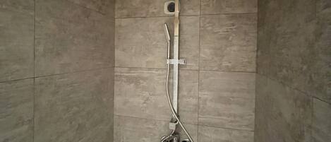 A shower with a handheld showerhead and a wall-mounted faucet.