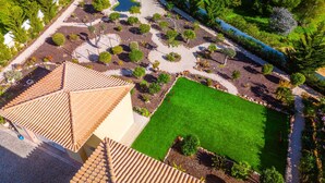 An aerial view of a landscaped garden with a central lawn, surrounded by various shrubs and trees. - Villa w/ Heatable Pool and Jacuzzi in Carvoeiro (Carvoeiro)