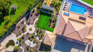 An aerial view of a property with a swimming pool, a tennis court, and a landscaped garden. - Villa w/ Heatable Pool and Jacuzzi in Carvoeiro (Carvoeiro)