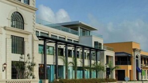 A modern building with a glass facade, a covered outdoor area, and a traditional building with arched windows. - Sunset Nook: Cozy one bedroom apartment

 (Saint James)